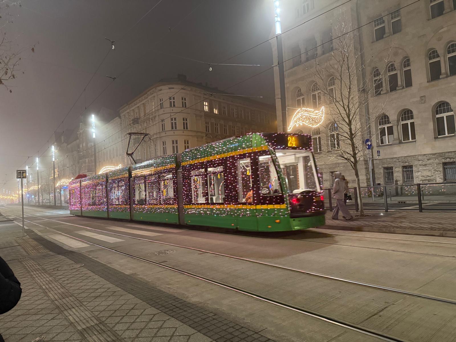 Świątecznie oświetlony tramwaj na wieczornej ulicy